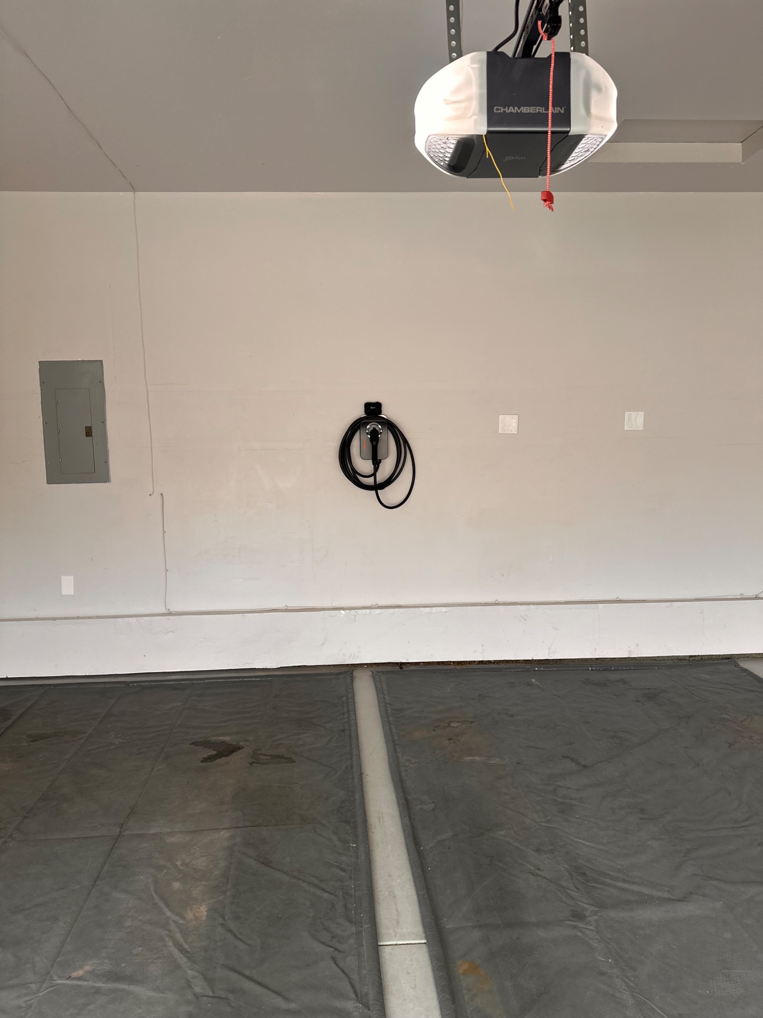 Home EV charger positioned on a garage wall near the electrical panel