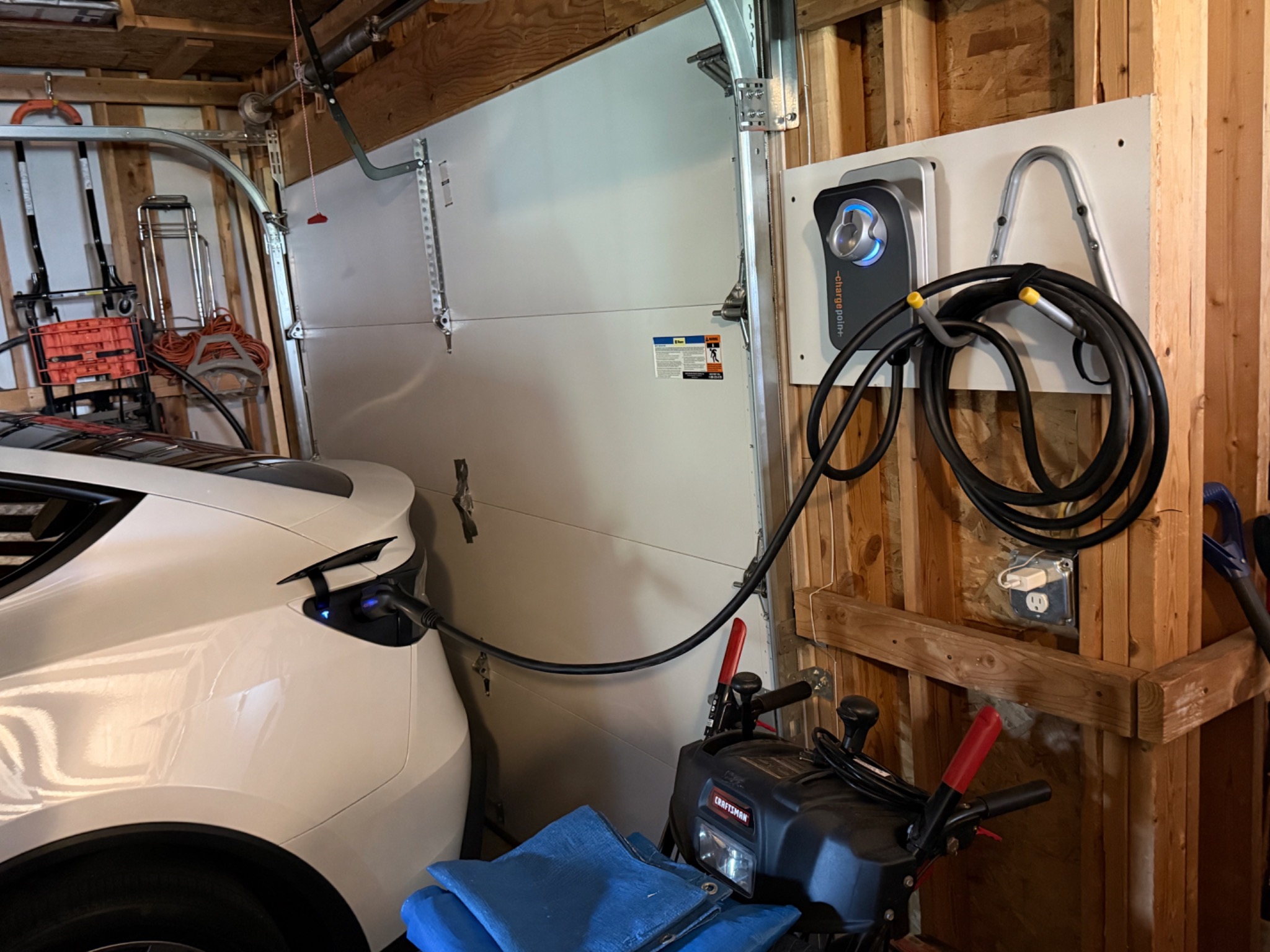 A ChargePoint home charger installed by Day Electric, connected to a vehicle in a garage